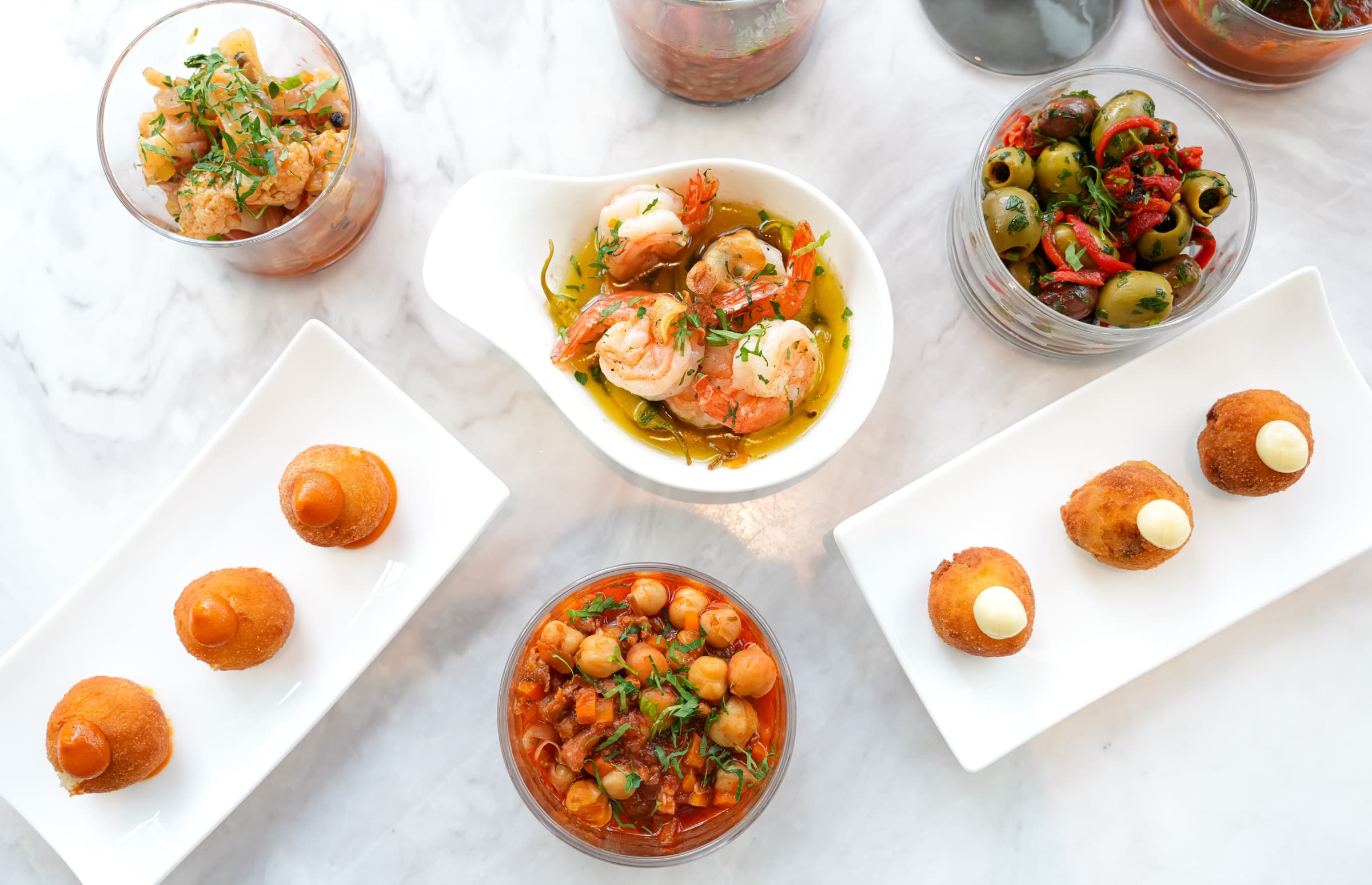 Small plates laid out on white marble, shot from above in daylight